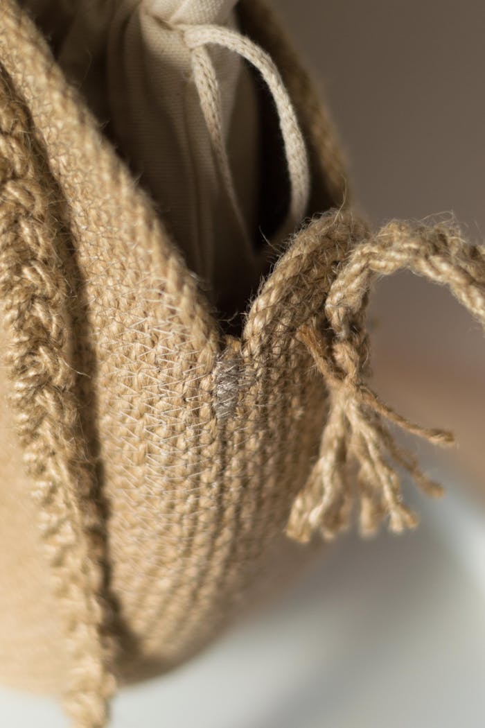 A detailed close-up of a woven jute bag with focus on its rustic knot, showcasing texture.