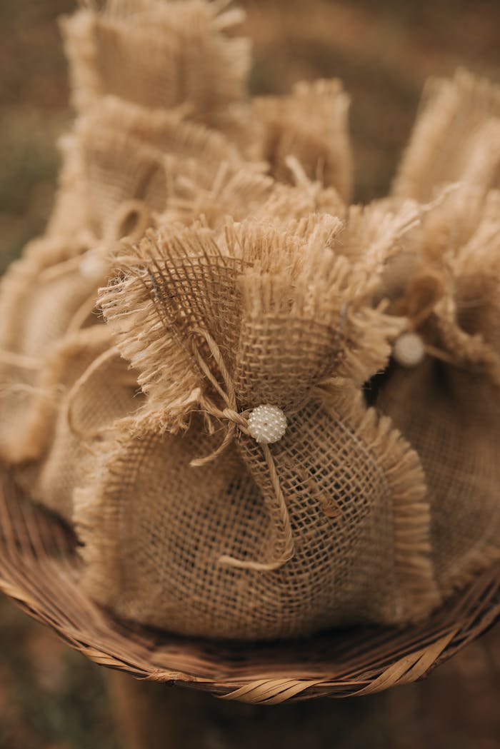 A collection of burlap sacks tied with twine, creating a rustic and natural look outdoors.